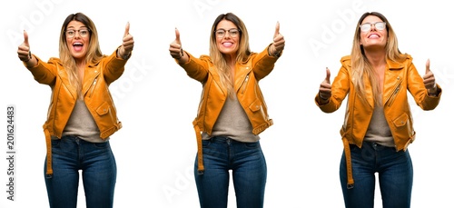 Beautiful young woman stand happy and positive with thumbs up approving with a big smile expressing okay gesture over white background