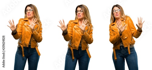 Beautiful young woman disgusted and angry  keeping hands in stop gesture  as a defense  shouting over white background