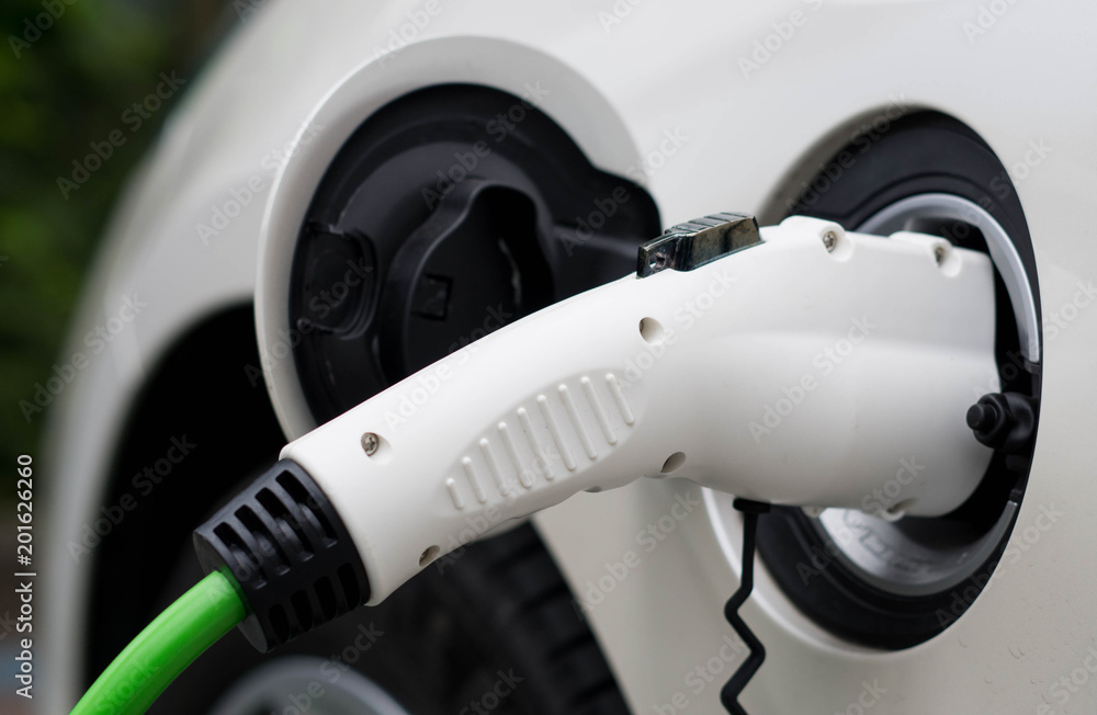 Close up of an electric car charging with the power cable supply plugged in. Close up of an electric car charging with the power cable supply plugged in.