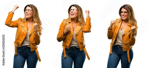 Beautiful young woman happy and excited celebrating victory expressing big success  power  energy and positive emotions. Celebrates new job joyful over white background