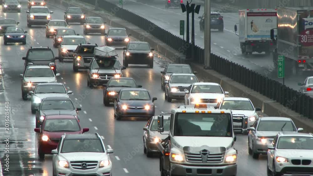Multiple cars driving slowly in traffic jam on highway in angled closeup Multiple cars driving slowly in traffic jam on highway in angled closeup