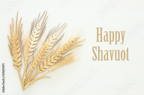 top view of wooden wheat crop decoration over white background. Symbols of jewish holiday - Shavuot.
