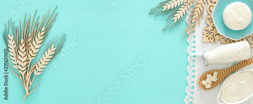 Top view image of dairy products over mint wooden background. Symbols of jewish holiday - Shavuot.