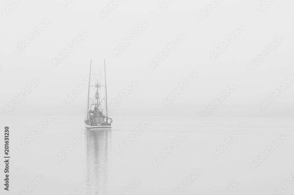 Boat sails out through the fog for another day of fishing along the California coast