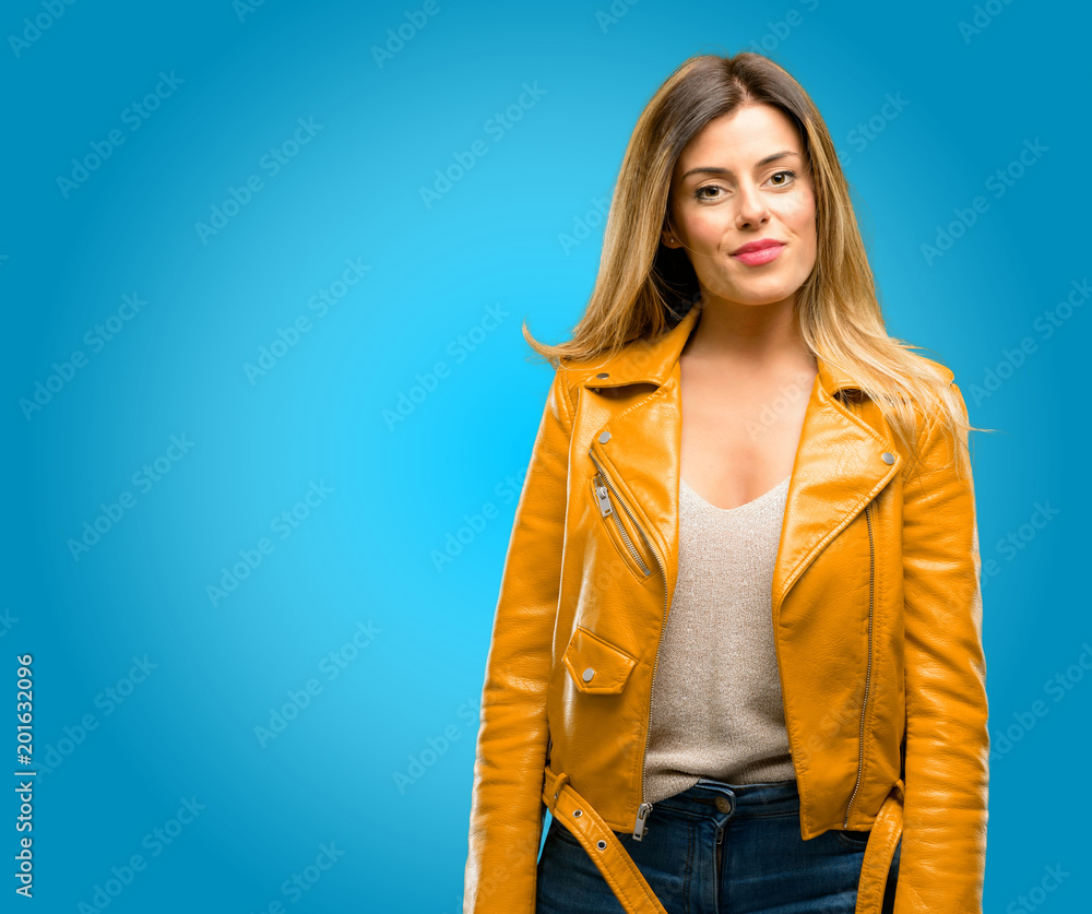 Beautiful young woman confident and happy with a big natural smile laughing, blue background Beautiful young woman confident and happy with a big natural smile laughing, blue background
