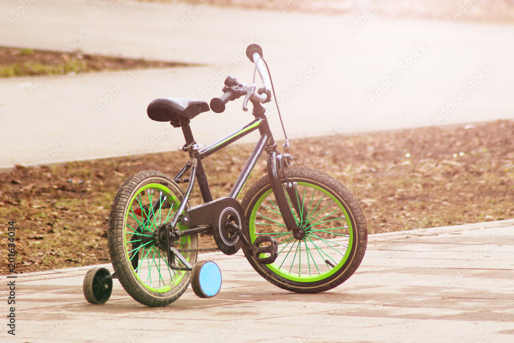 Fototapeta premium Green children's bike at sunset.