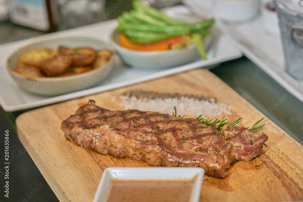 Steak with dip ,pepper,salt and thyme leaf on wooden plate Steak with dip ,pepper,salt and thyme leaf on wooden plate
