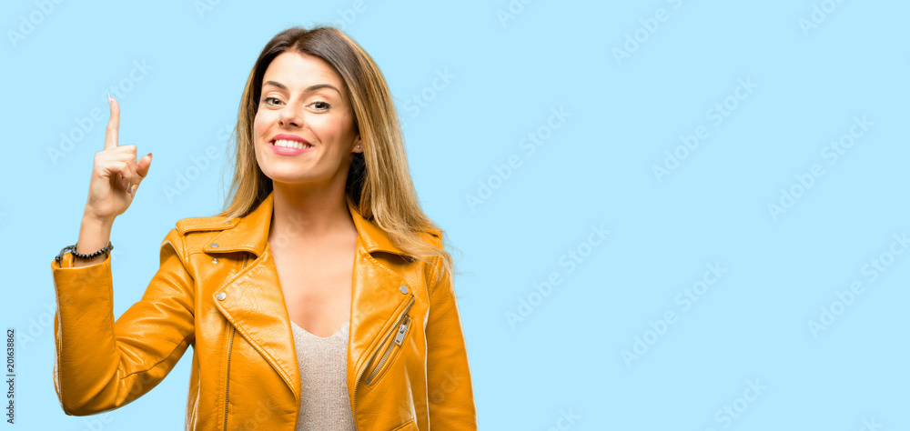 Beautiful young woman raising his finger, the number one Beautiful young woman raising his finger, the number one
