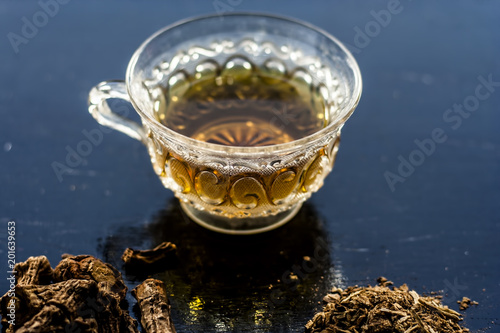 Indian sarsaparilla or Nannari with its tea in a transparent cup helps in protecting Liver and Has Natural Diuretic, Detoxifying Abilities, Promotes Hormonal Balance etc. photo