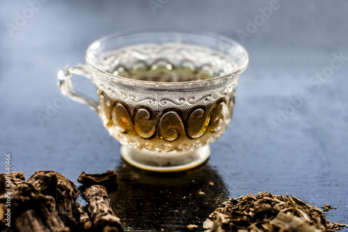 Indian sarsaparilla or Nannari with its tea in a transparent cup helps in protecting Liver and Has Natural Diuretic, Detoxifying Abilities, Promotes Hormonal Balance etc. photo