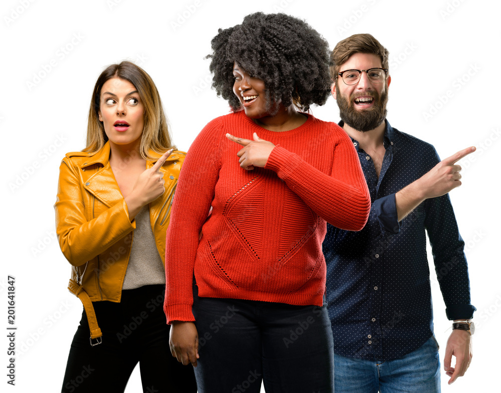 Group of three young men and women pointing away side with finger Group of three young men and women pointing away side with finger