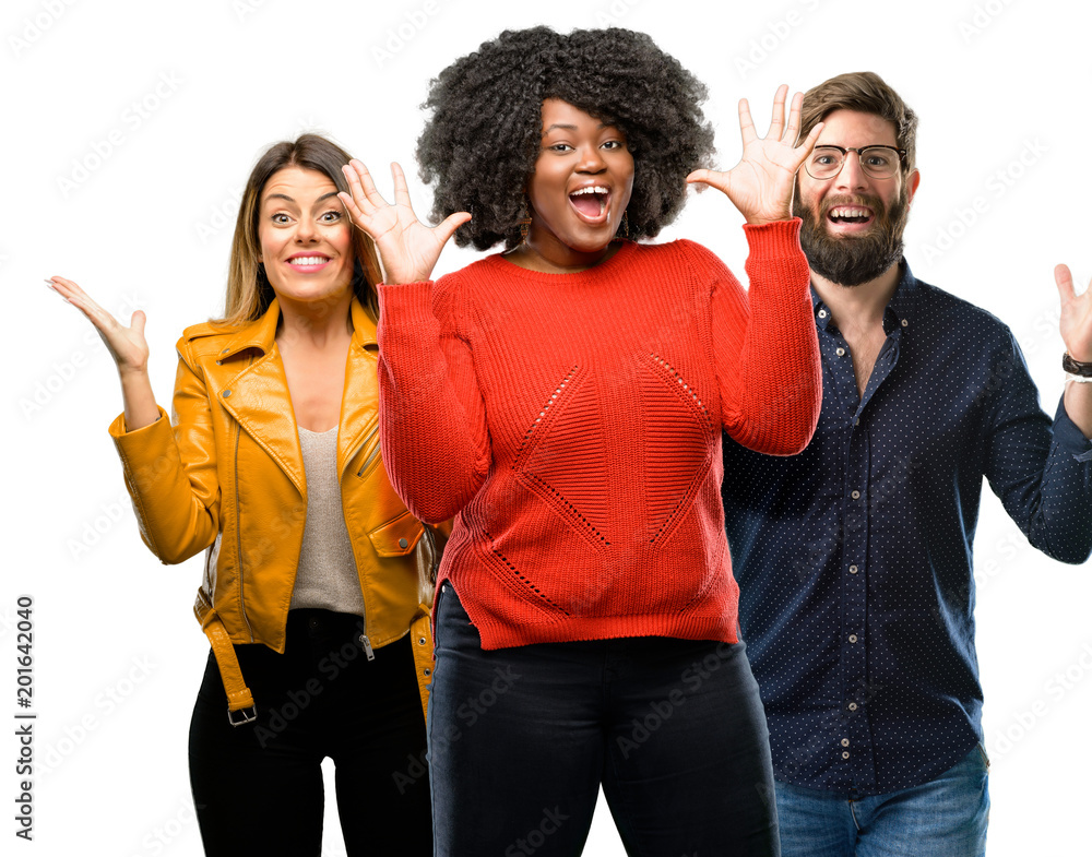 Group of three young men and women happy and surprised cheering expressing wow gesture Group of three young men and women happy and surprised cheering expressing wow gesture