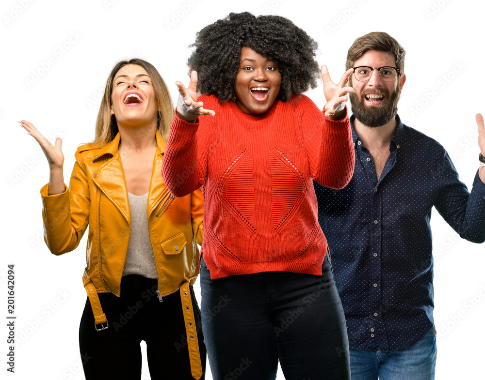Group of three young men and women happy and surprised cheering expressing wow gesture Group of three young men and women happy and surprised cheering expressing wow gesture