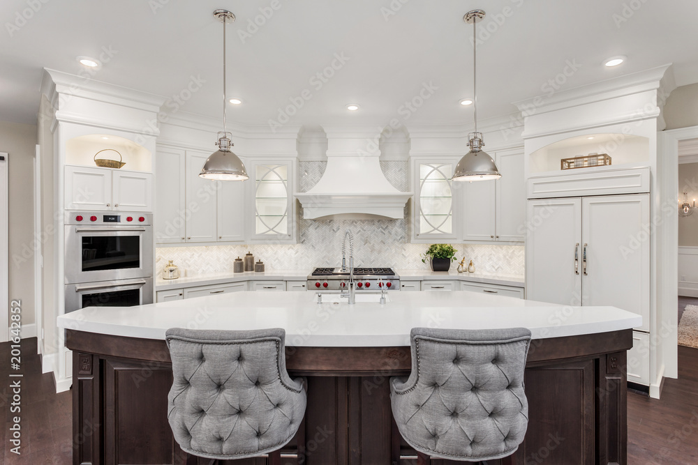 Kitchen in new luxury home: large, elegant kitchen, with pendant lights, and huge island, with refrigerator and double ovens.  - obrazy, fototapety, plakaty 
