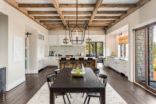 Stunning dining room and kitchen in new luxury home.Wood beams and elegant pendant lights accent this beautiful open-plan dining room and kitchen