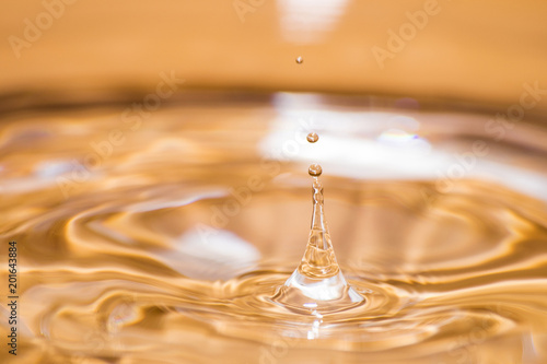 Shining drop of water colored of orange isolated