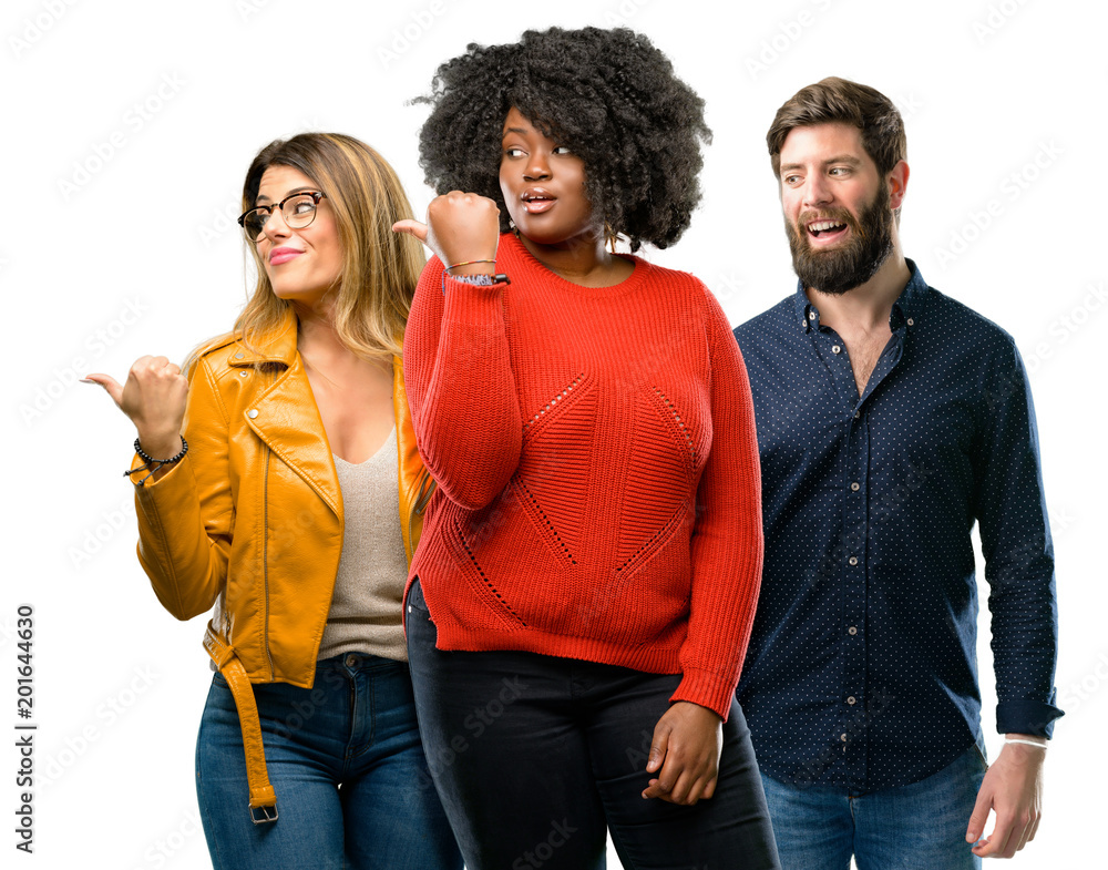 Group of three young men and women pointing away side with finger Group of three young men and women pointing away side with finger