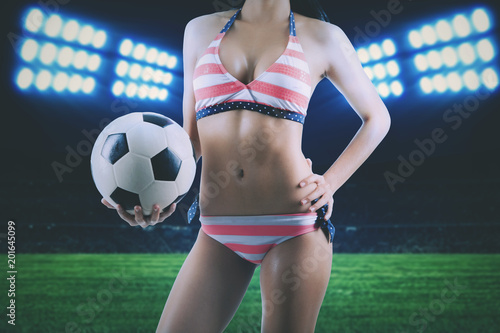 Anonymous woman with soccer ball in stadium © Creativa Images