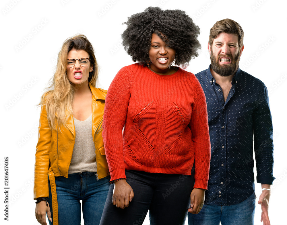 Group of three young men and women angry and stressful frowns face in dissatisfaction, irritated and annoyed, expressing anger Group of three young men and women angry and stressful frowns face in dissatisfaction, irritated and annoyed, expressing anger