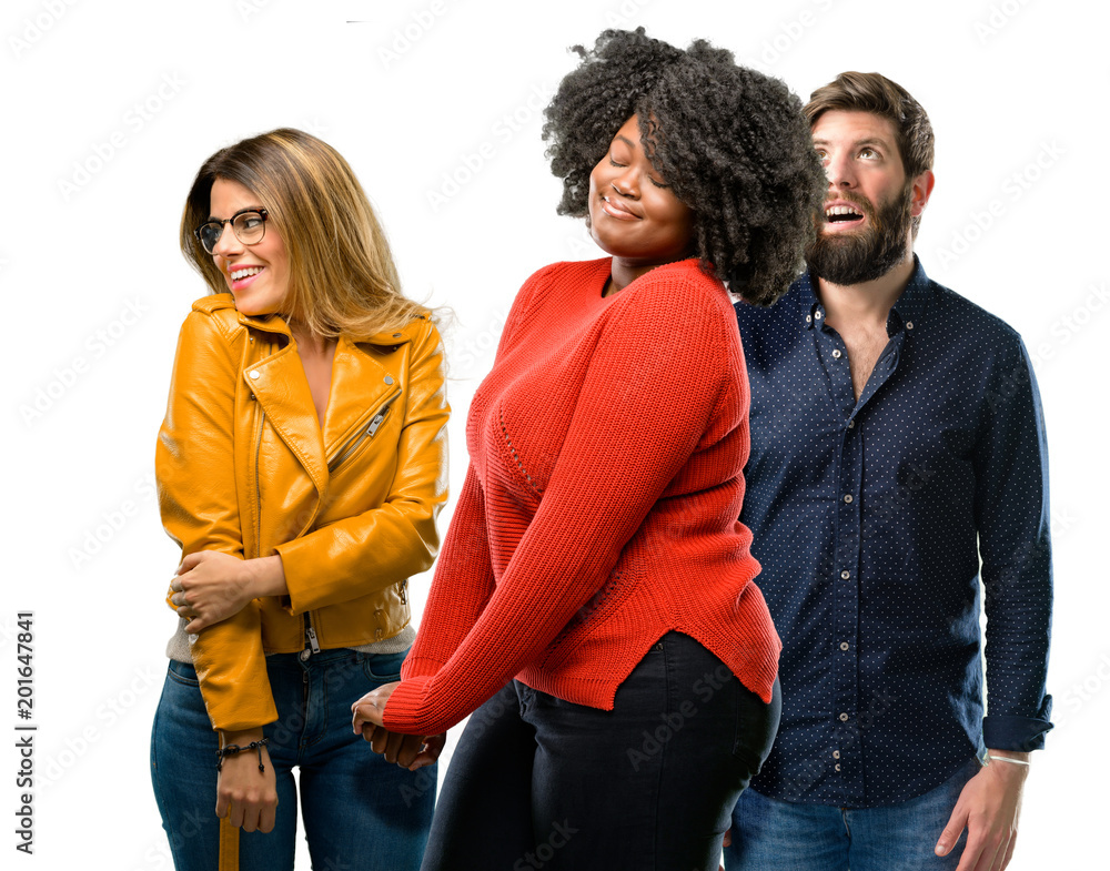 Group of three young men and women confident and happy with a big natural smile laughing looking up Group of three young men and women confident and happy with a big natural smile laughing looking up