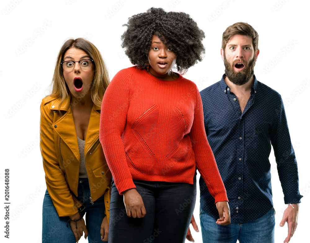Group of three young men and women scared and surprised cheering expressing wow gesture. Unbelieving Group of three young men and women scared and surprised cheering expressing wow gesture. Unbelieving