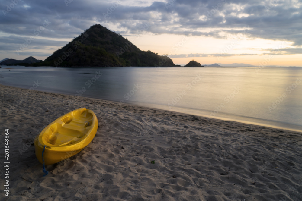 Beautiful sunset with empty yellow canoe