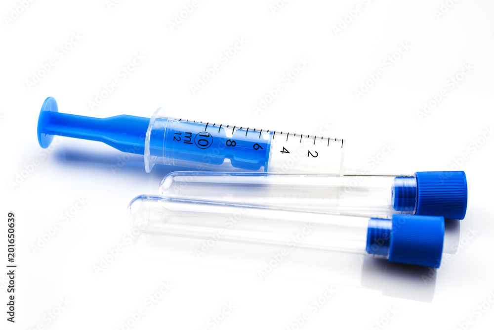Syringes and test tubes lying on a white table. Medical background concept. Syringes and test tubes lying on a white table. Medical background concept.