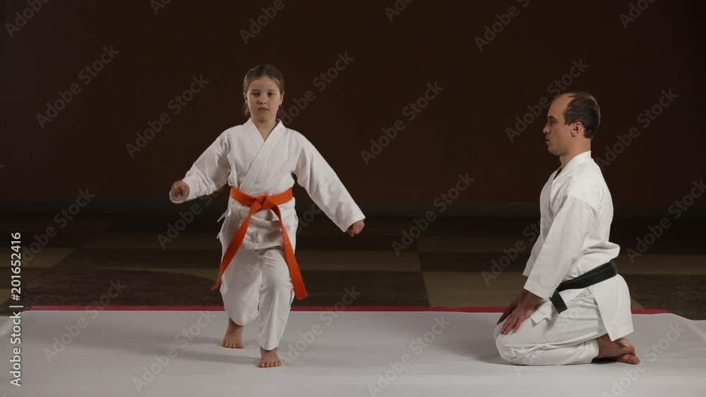 Girl athlete is training kicks under the guidance of a coach Girl athlete is training kicks under the guidance of a coach