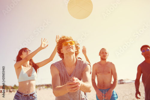 Group of friends playing at beach volley at the beach