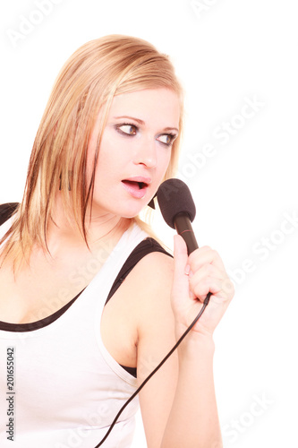 Blonde woman singing to microphone