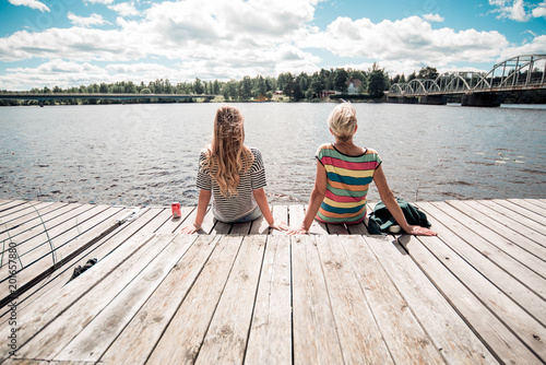 Two women sitting and watching on the lake