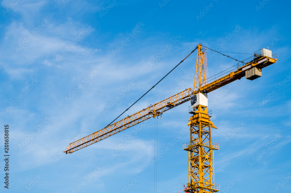 Orange crane against blue clear sky, copy space