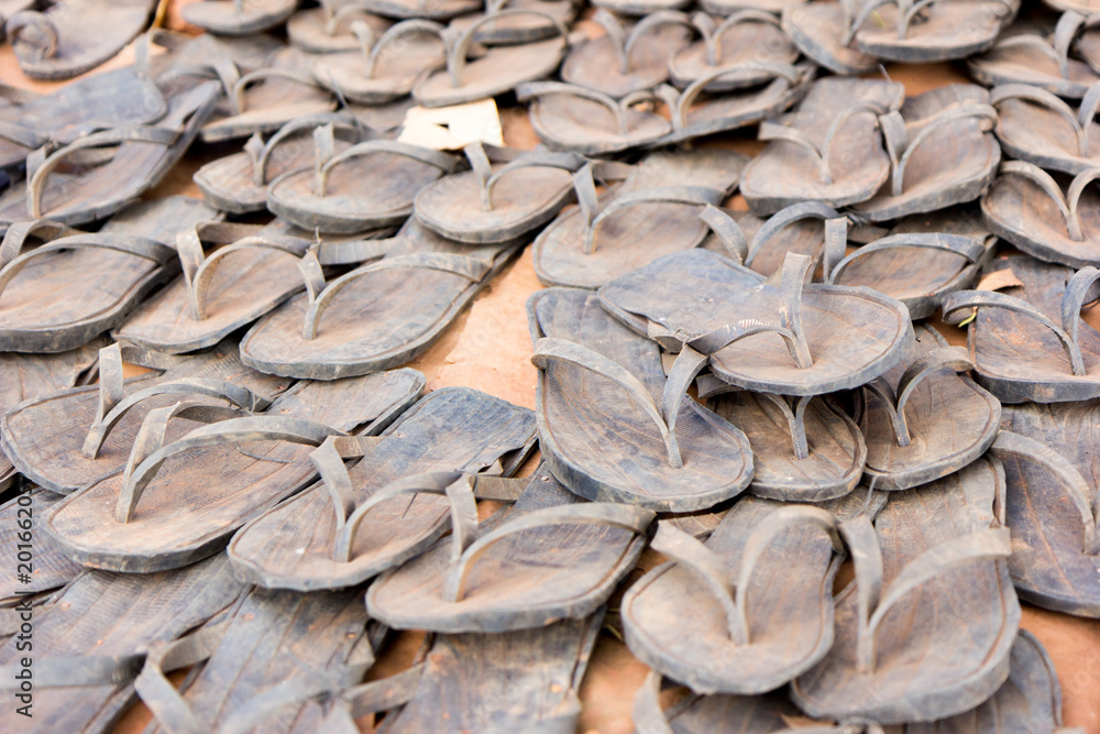 A sale of flip-flops made out of tyres in a marketplace.