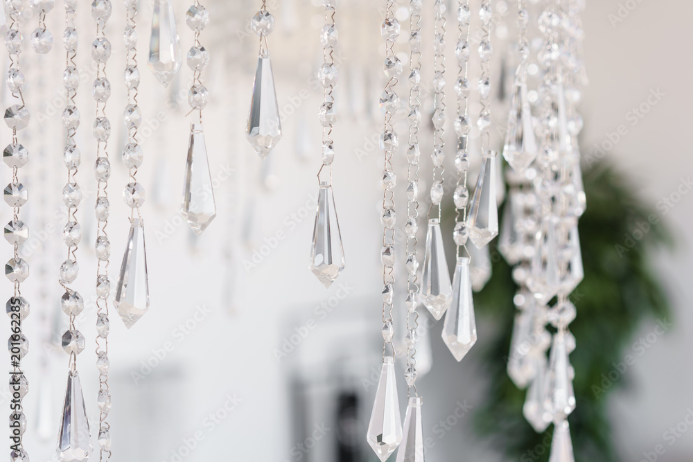 Contemporary crystal chandelier in room interior. Close up. The interior of a bright room of an apartment or a hotel