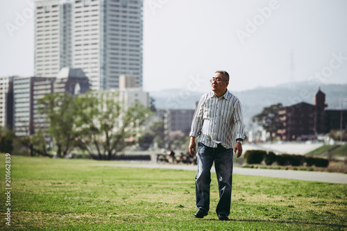 芝生の上を歩くシニア男性