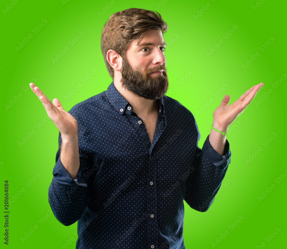 Young hipster man with big beard doubt expression, confuse and wonder concept, uncertain future over green background Young hipster man with big beard doubt expression, confuse and wonder concept, uncertain future over green background