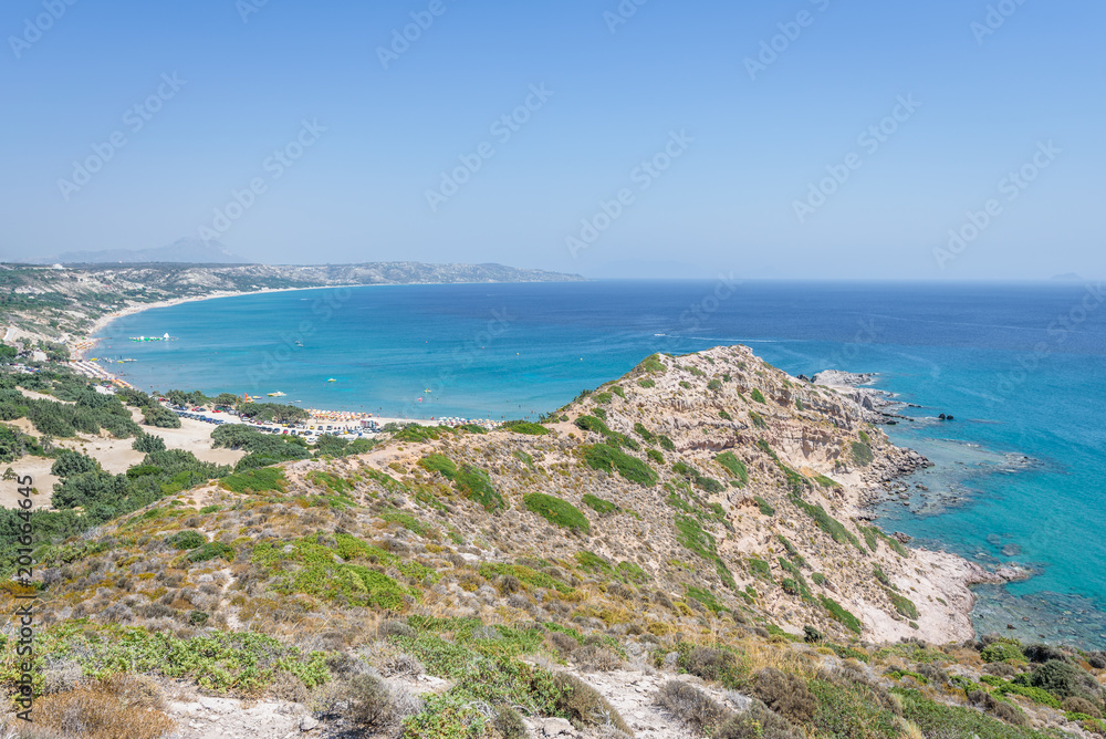 Beautiful sunny coast view to the greek mediterranean blue sea with crystal clear water and pure sandy beach empty place with some mountains rocks surrounded, Kos, Dodecanese Islands, Greece