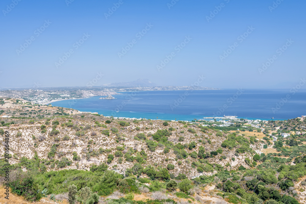 Beautiful sunny coast view to the greek mediterranean blue sea with crystal clear water and pure sandy beach empty place with some mountains rocks surrounded, Kefalos, Kos Island, Dodecanese, Greece