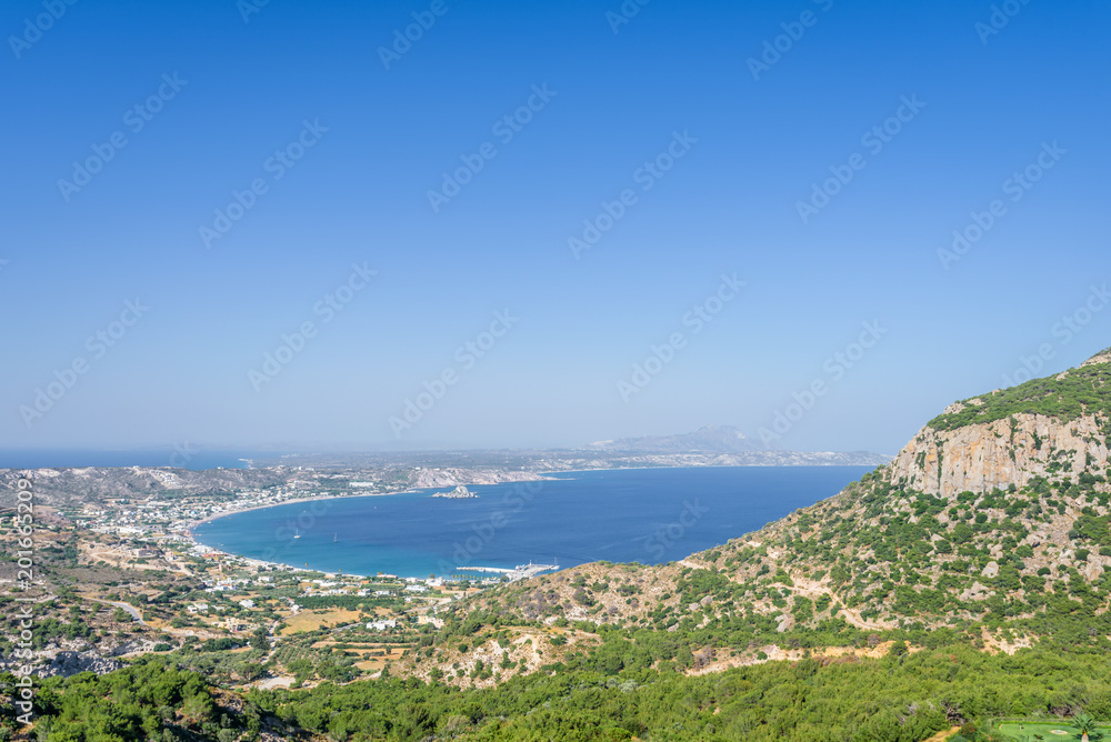 Beautiful sunny coast view to the greek mediterranean blue sea after a long hiking day resting at an empty place with some mountains rocks surrounded, Kefalos, Kos, Dodecanese Islands, Greece