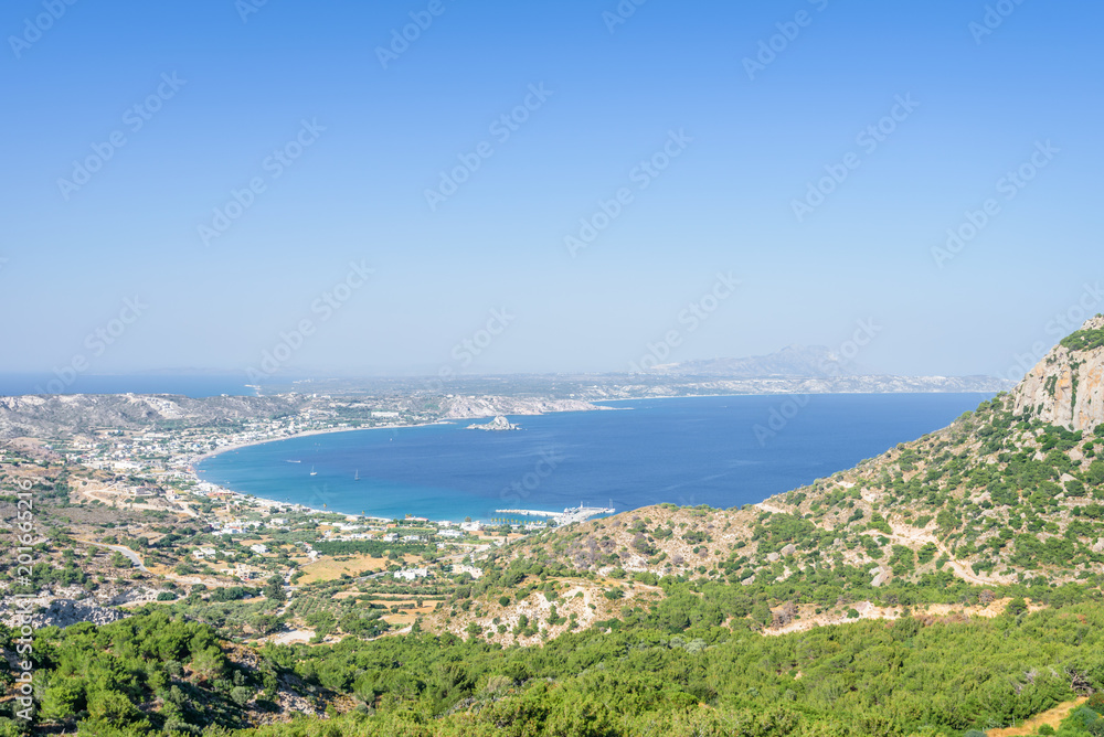 Beautiful sunny coast view to the greek mediterranean blue sea after a long hiking day resting at an empty place with some mountains rocks surrounded, Kefalos, Kos, Dodecanese Islands, Greece