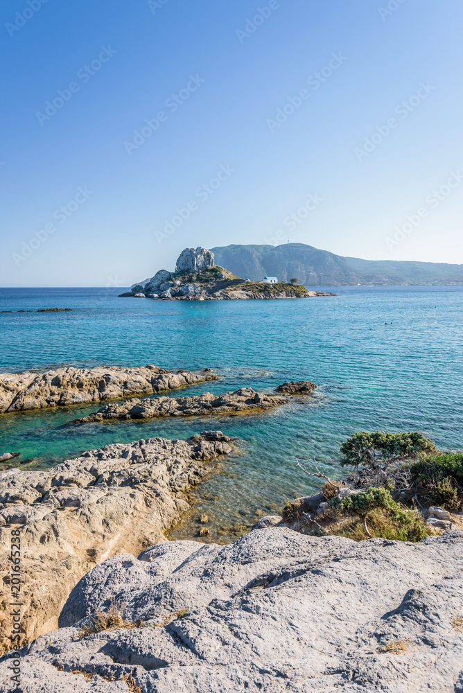 Kos Island, Kastri, Dodecanese, Greece: Beautiful sunny coast view to greek mediterranean blue sea with crystal clear water at ancient traditional place or old temple church area near a small islet