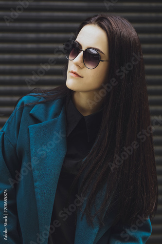 Obraz na płótnie Beautiful brunette girl. Fashionable, stylish with black hair, in coats, jeans and sunglasses w salonie