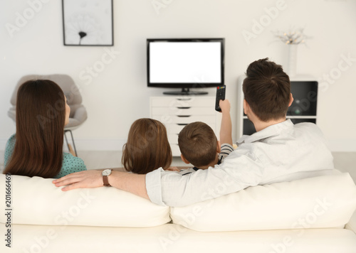 Family watching TV on sofa ...