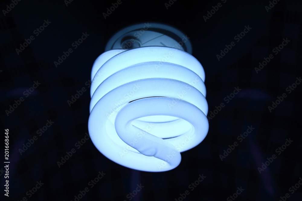 Spiral LED lamp. Close-up. Working. Background. Spiral LED lamp. Close-up. Working. Background.