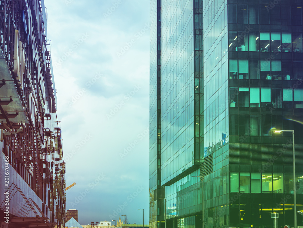 Fototapeta premium tall skyscrappers close up against cloudy stormy sky