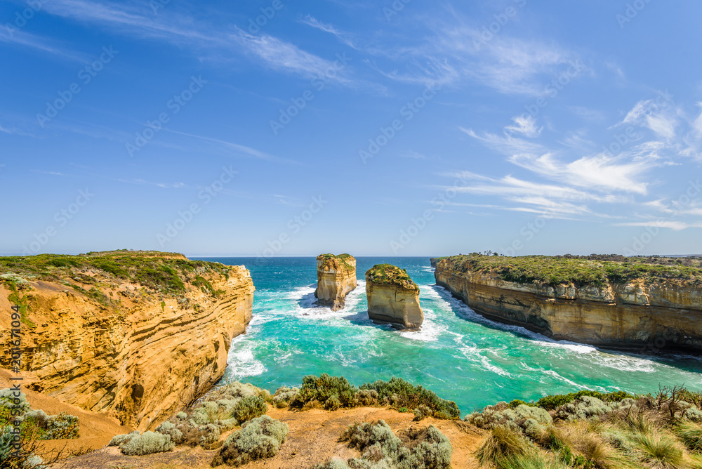 Bright sunny summer coast view to a beautiful sandy beach bay and rocky erosion sand limestone cliff of Great Ocean Road, walking at Loch Ard Gorge, Port Campbell National Park, Victoria/ Australia