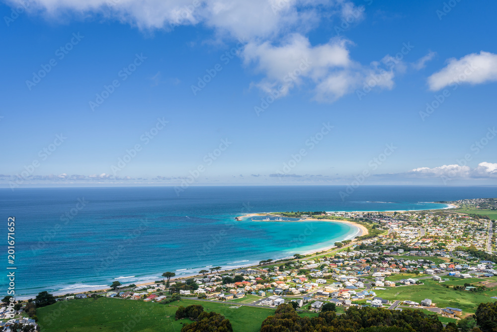 Relaxing at the blue Bass Strait sea and enjoying a warm sunny beach view over blue sky water of Great Ocean Road with a few clouds horizon over small town Apollo Bay, Melbourne, Victoria, Australia Relaxing at the blue Bass Strait sea and enjoying a warm sunny beach view over blue sky water of Great Ocean Road with a few clouds horizon over small town Apollo Bay, Melbourne, Victoria, Australia