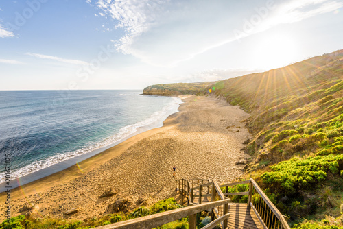 Bright sunny summer sunset sunrise coast view to wild Bass Strait sea, stairs lead you to empty sandy beach bay at Great Ocean Road, Torquay, best surfing relaxing, Australia