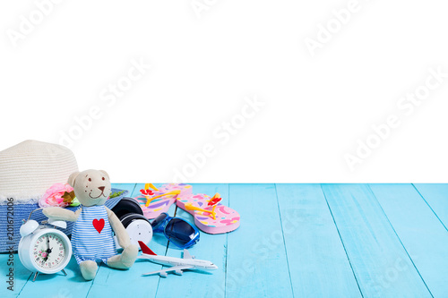 Teddy bear with white alarm clock,Beach accessory,hat,sunglasses,shoes on blue wooden plank background, concept summer holiday background and summer sale