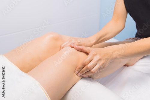 The specialist does massage of the knees to the client of the massage cabinet.